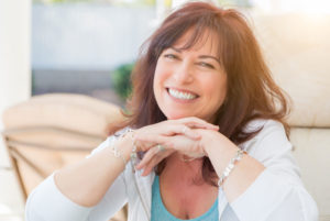 a patient smiling after her all on 4 dental implants procedure